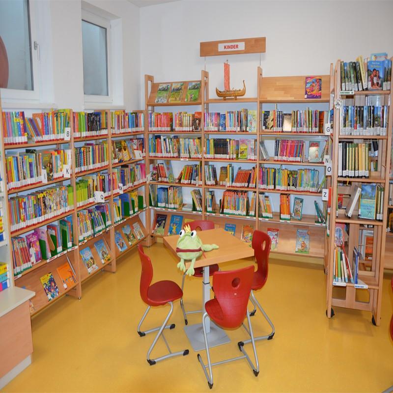 Kinderbereich mit Tisch und Sesseln. Froschstofftier sitzt am Tisch